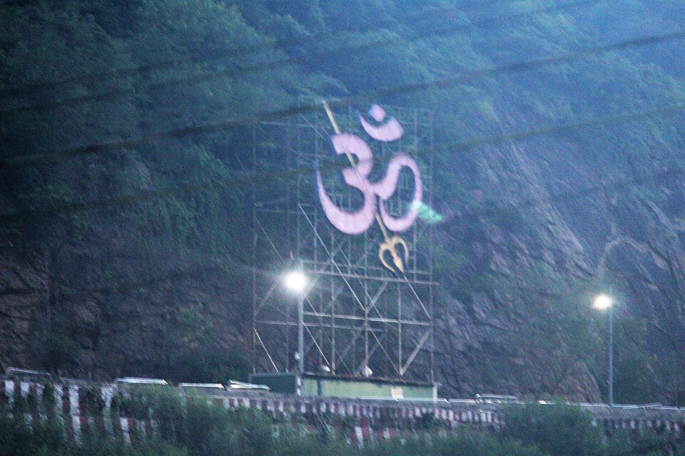 The illuminated OM symbol and trishul on the slopes of Indrakeeladri Hill